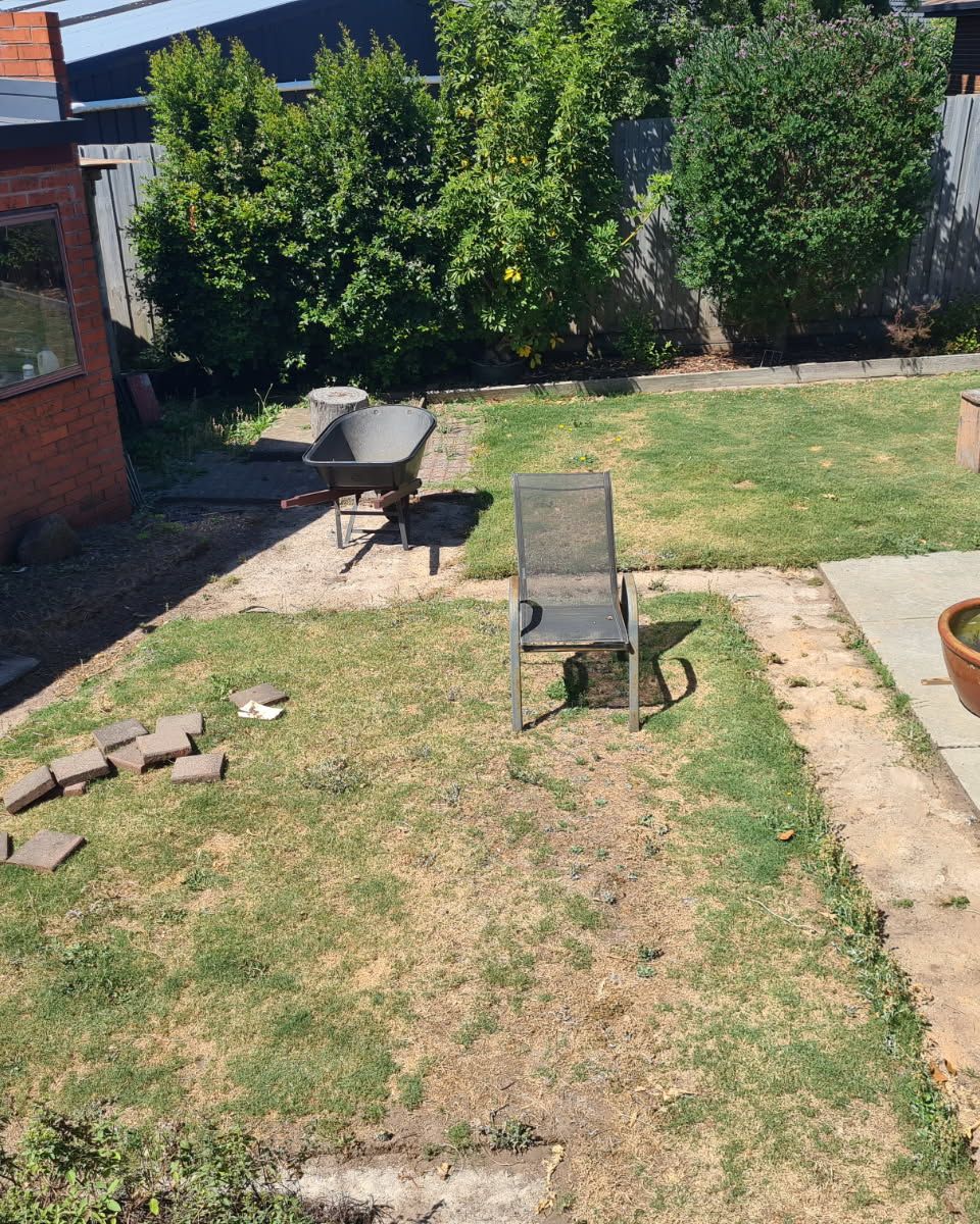 Patchy clay lawn with scattered pavers — Clifton Springs backyard before Titan installed new turf.