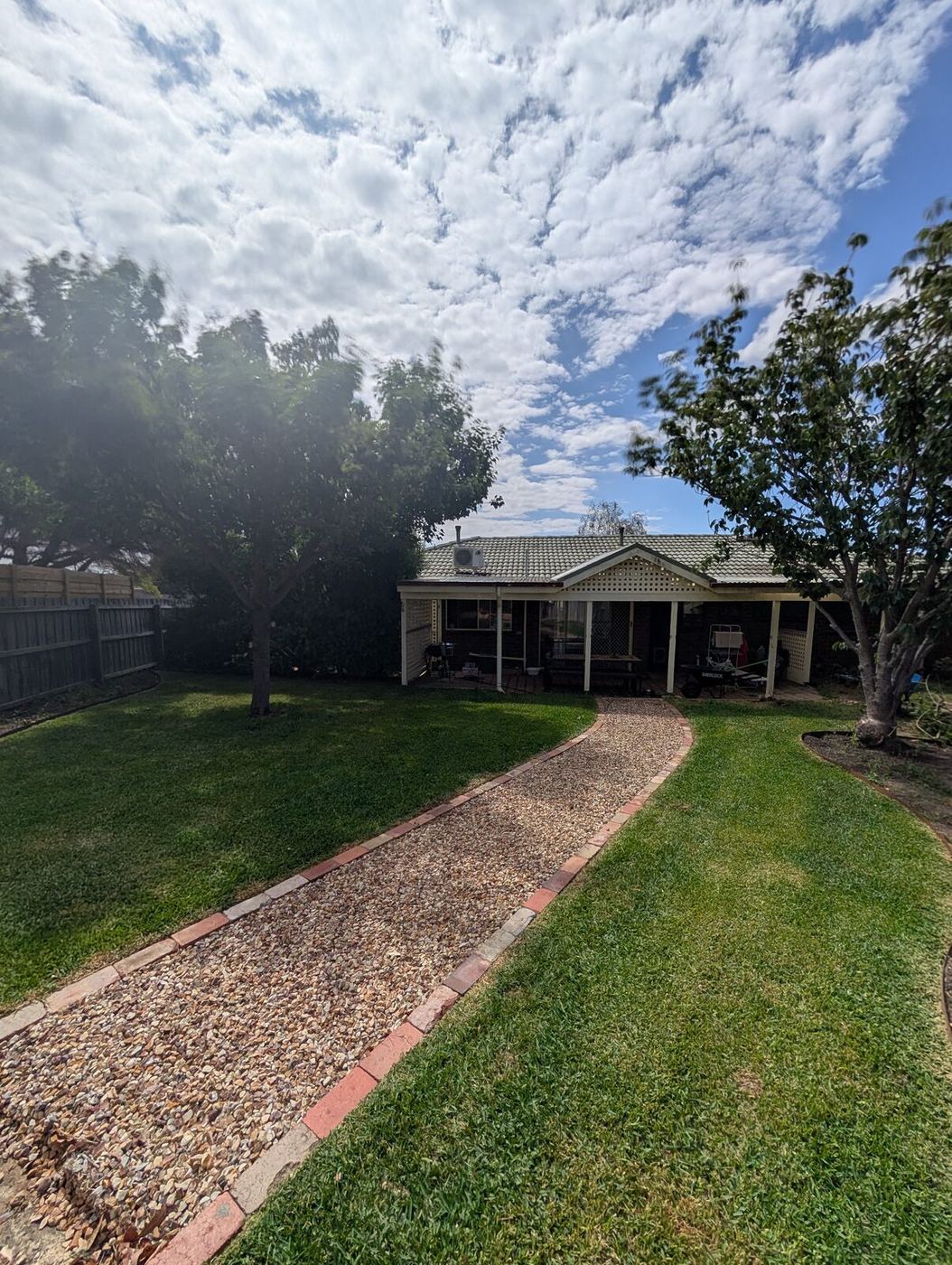 Backyard upgrade in Leopold — turf, gravel path, brick edging.